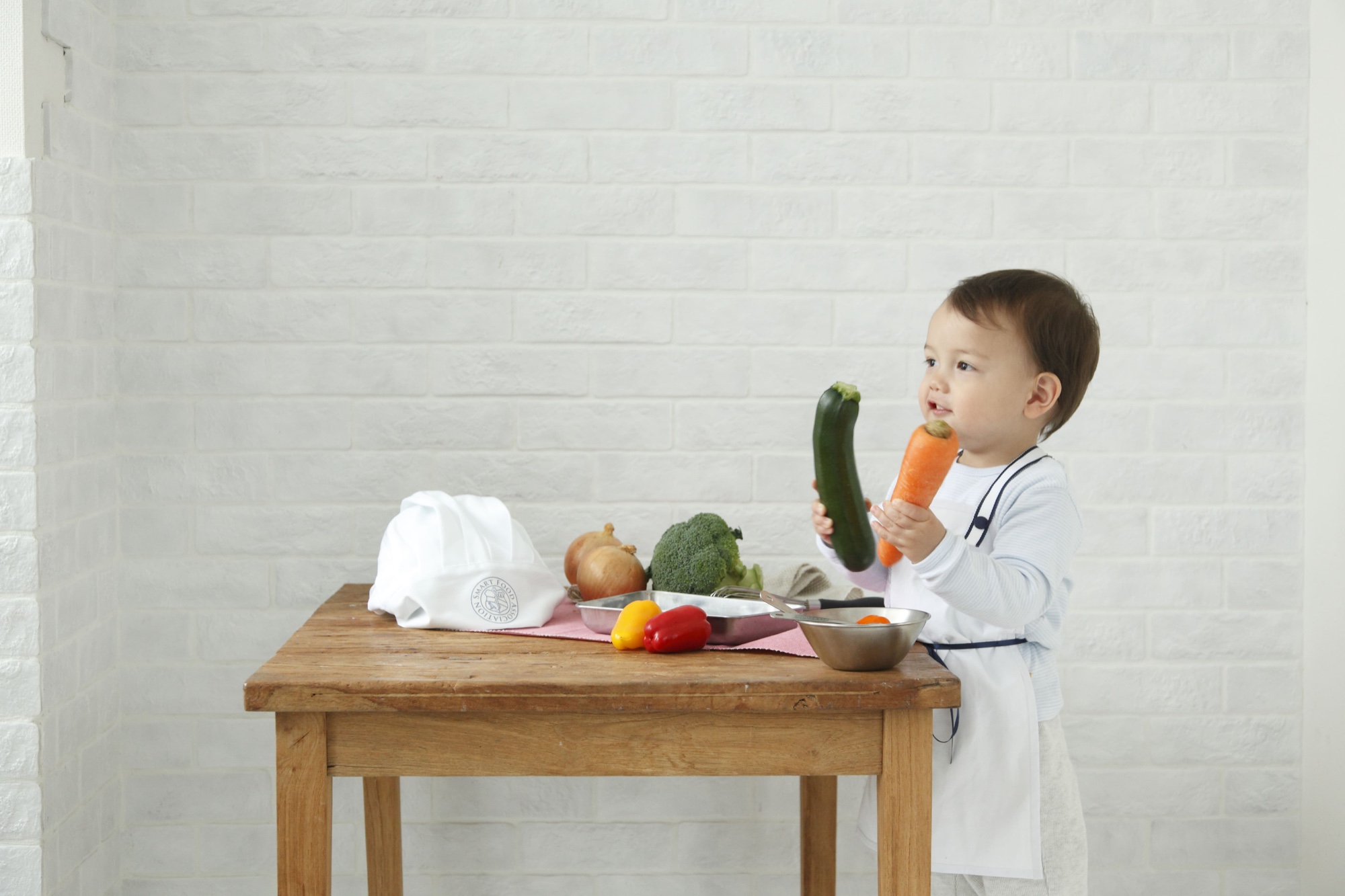 木のテーブルで野菜にふれる子ども