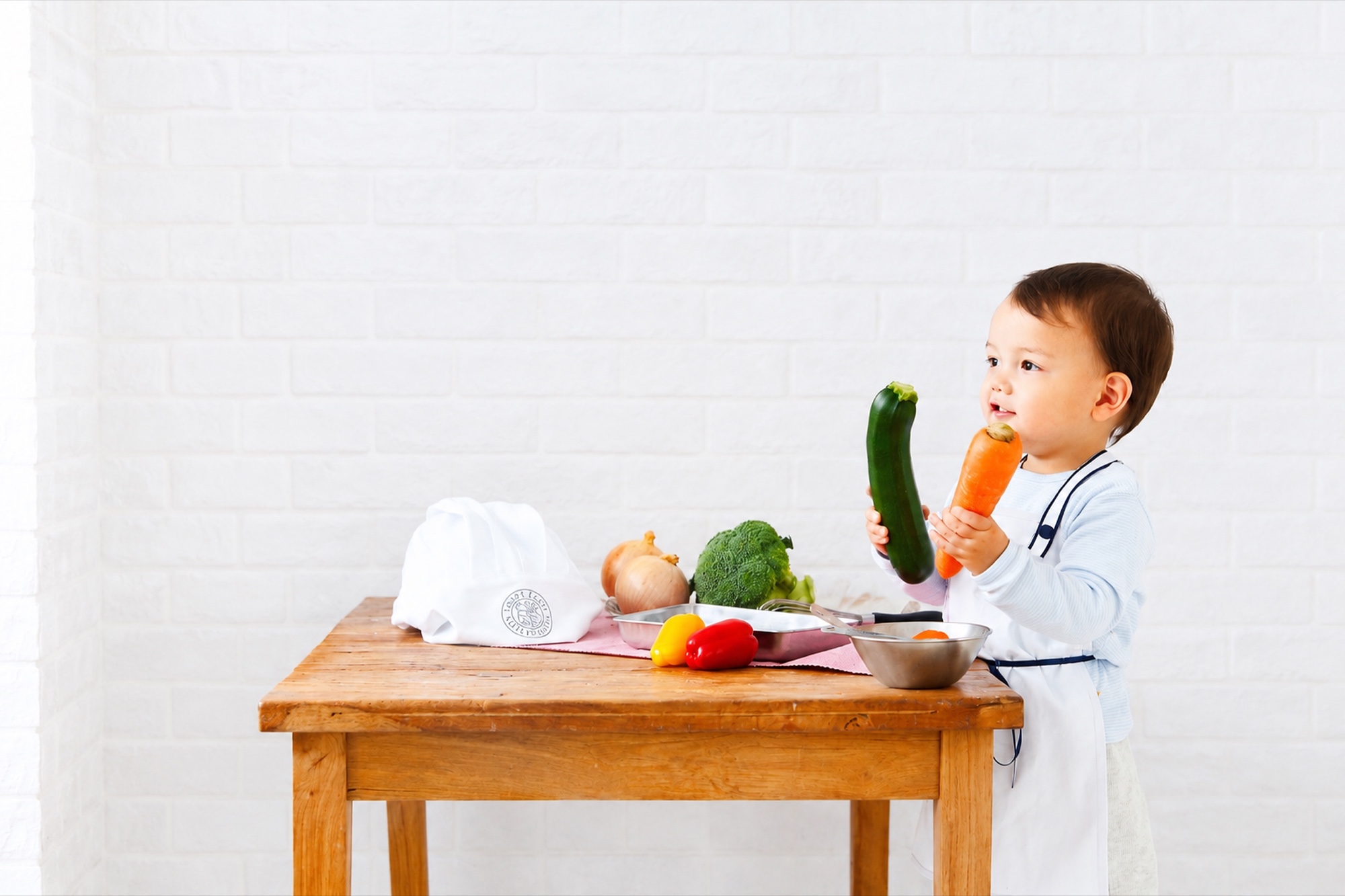 木のテーブルで野菜にふれる子ども