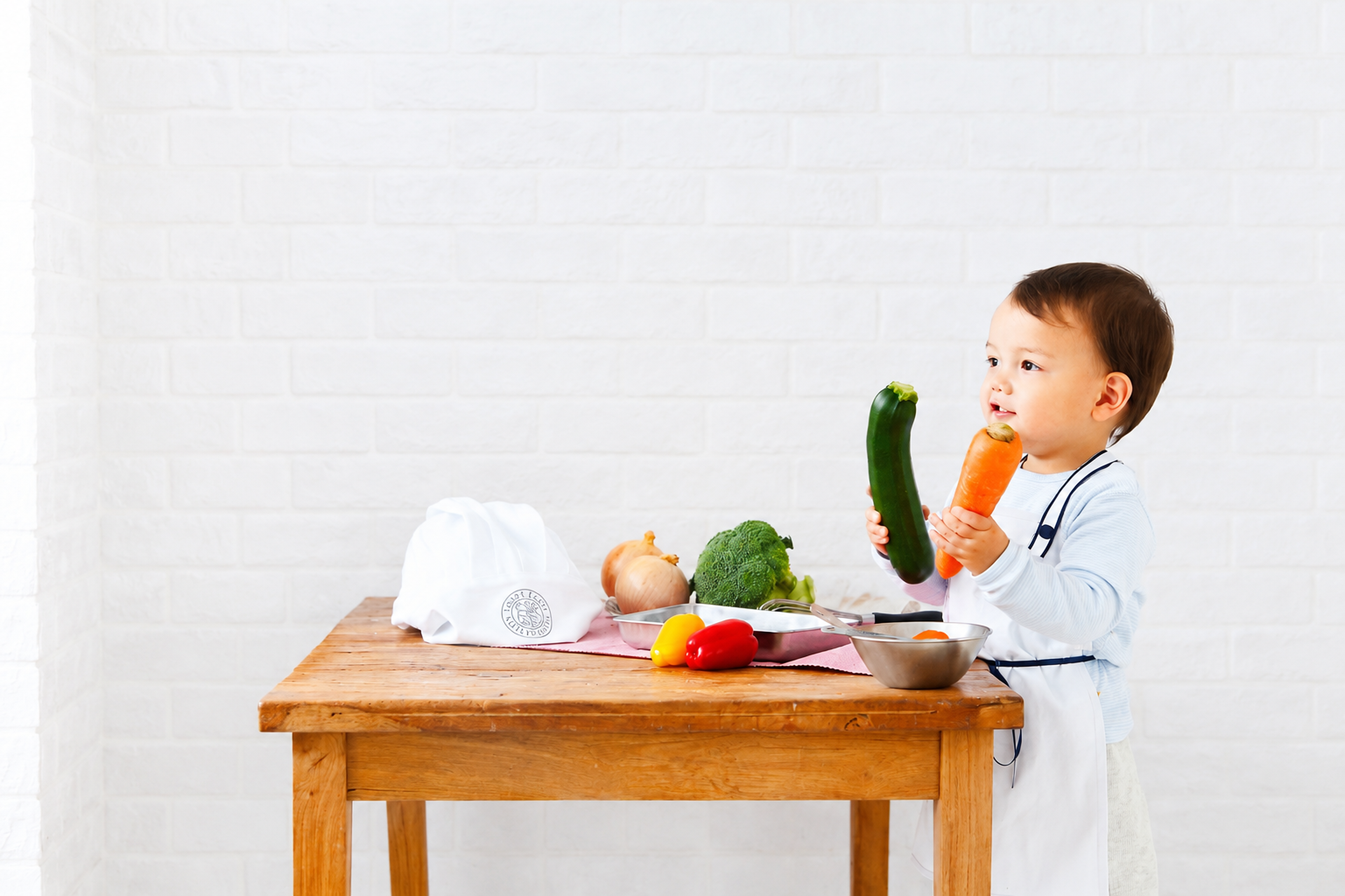 木のテーブルで野菜にふれる子ども